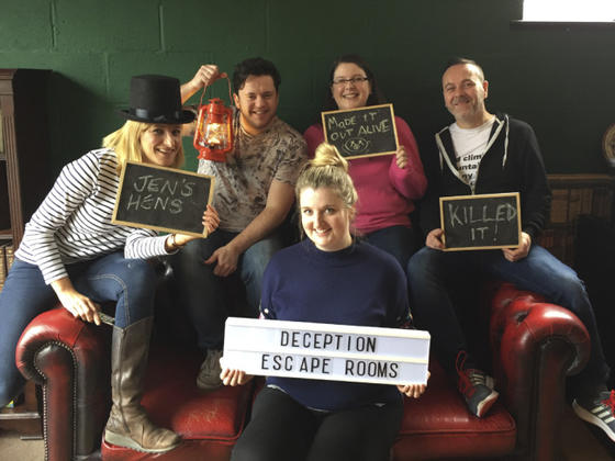 People sat on a leather sofa who have had fun in the escape rooms